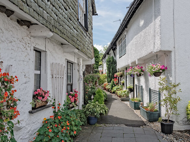An alley of whitewashed buildings and colourful flowers in Hawkshead