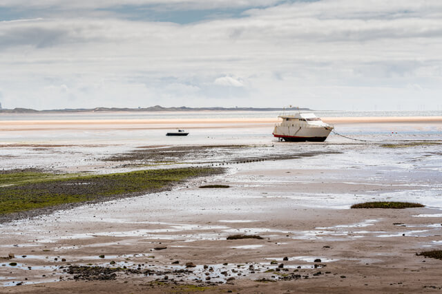Boats on the shore at low tide at Haverigg Beach