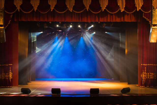 An empty theatre stage lit up by spotlights