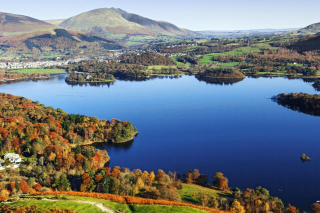 A view across a lake with Friars Crag peak in the distance