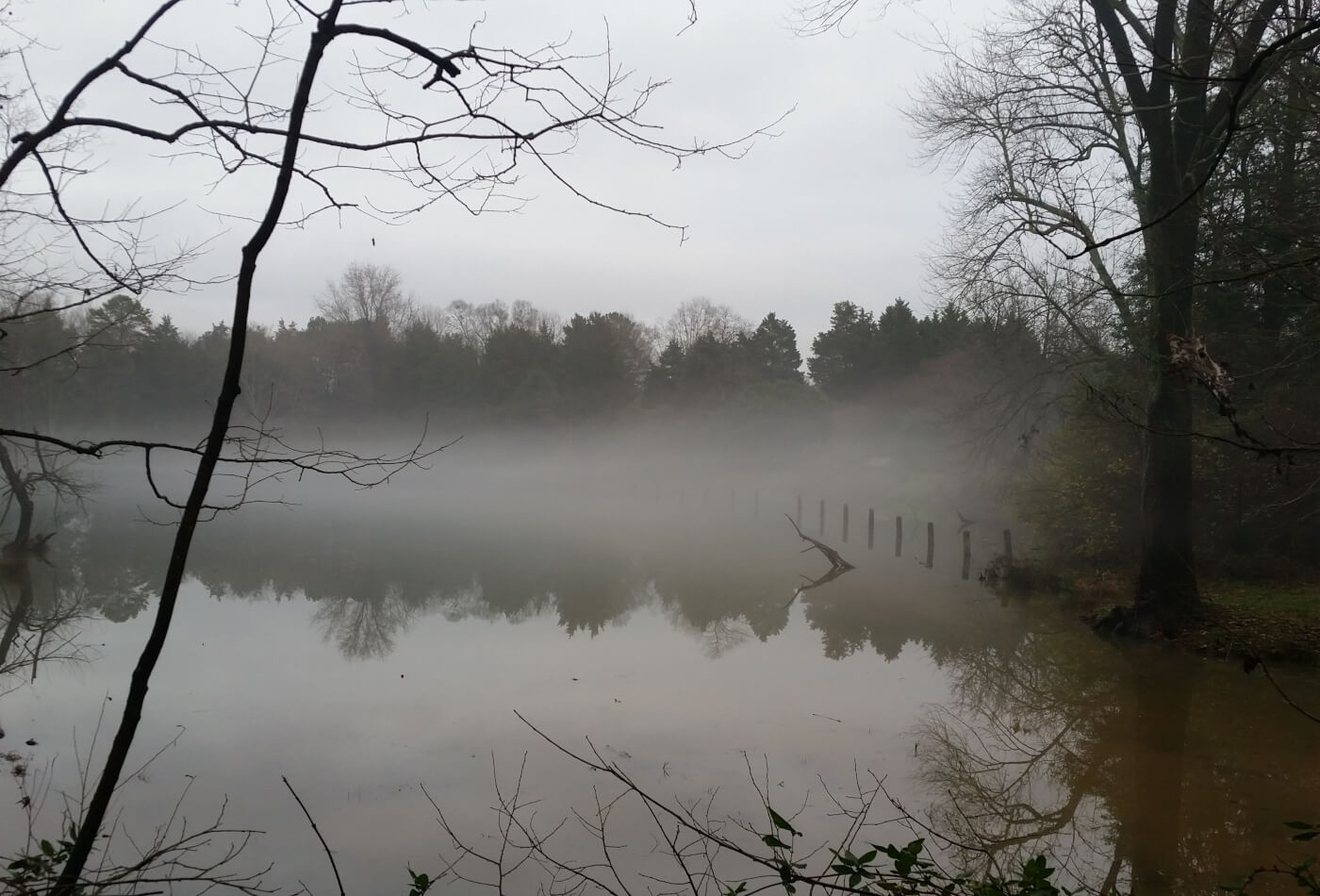 A view across a gloomy black and white lake