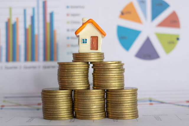 A small house sat on a stack of golden coins