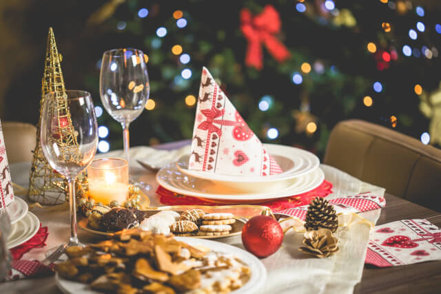 Table set for Christmas with a candle and Christmas decorations.