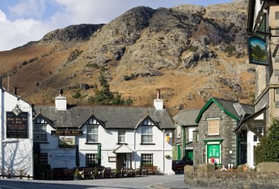 Coniston village centre and Black Bull pub with fell behind.