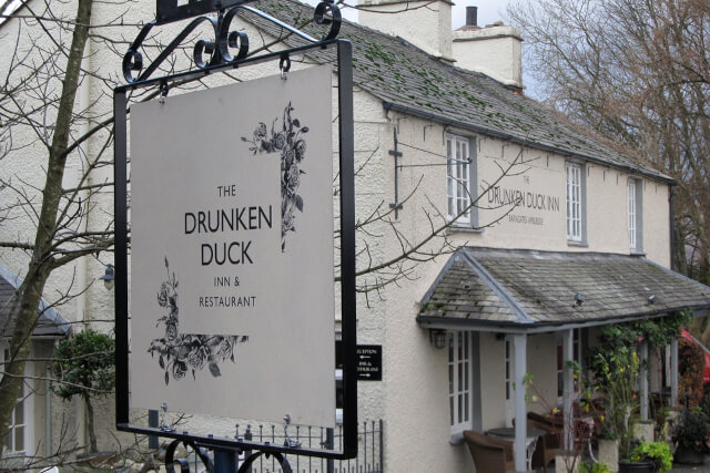 An external shot of the Drunken Duck Inn showing the sign and the whitewashed building