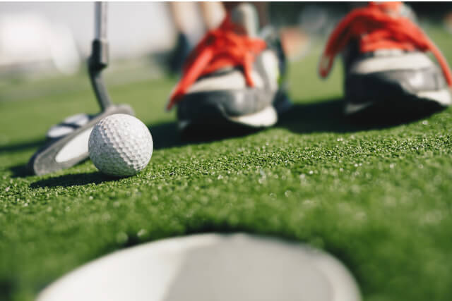 A child playing mini golf