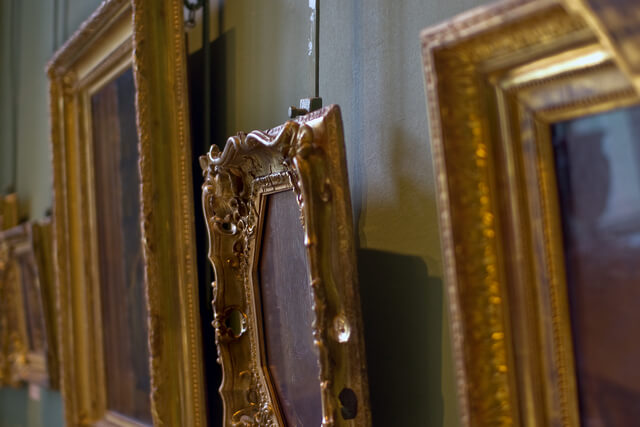 Gold frames hanging on a wall in an art gallery