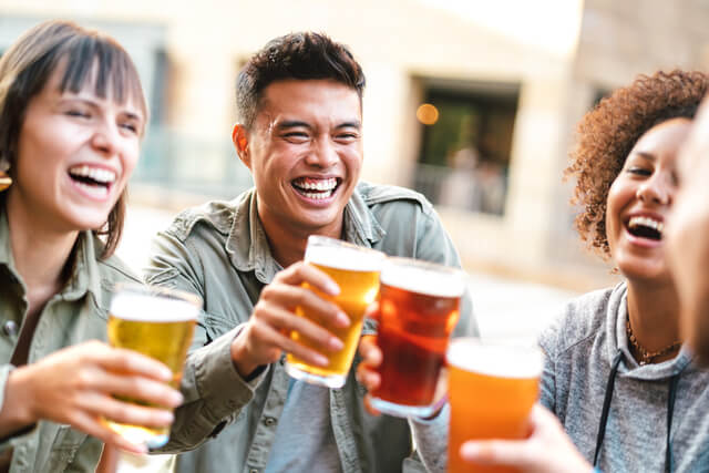 A group of friends clinking glasses of beer in a beer garden