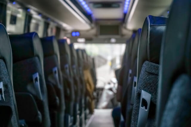 A view of the aisle from the back seat of a shuttle bus