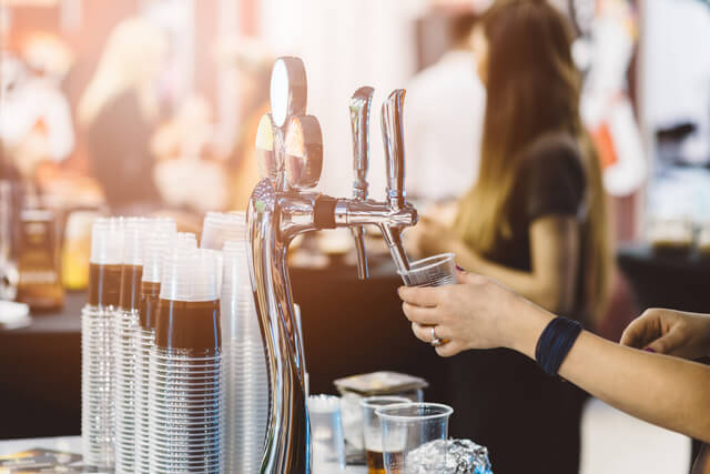 A woman pouring a pint at a festival bar