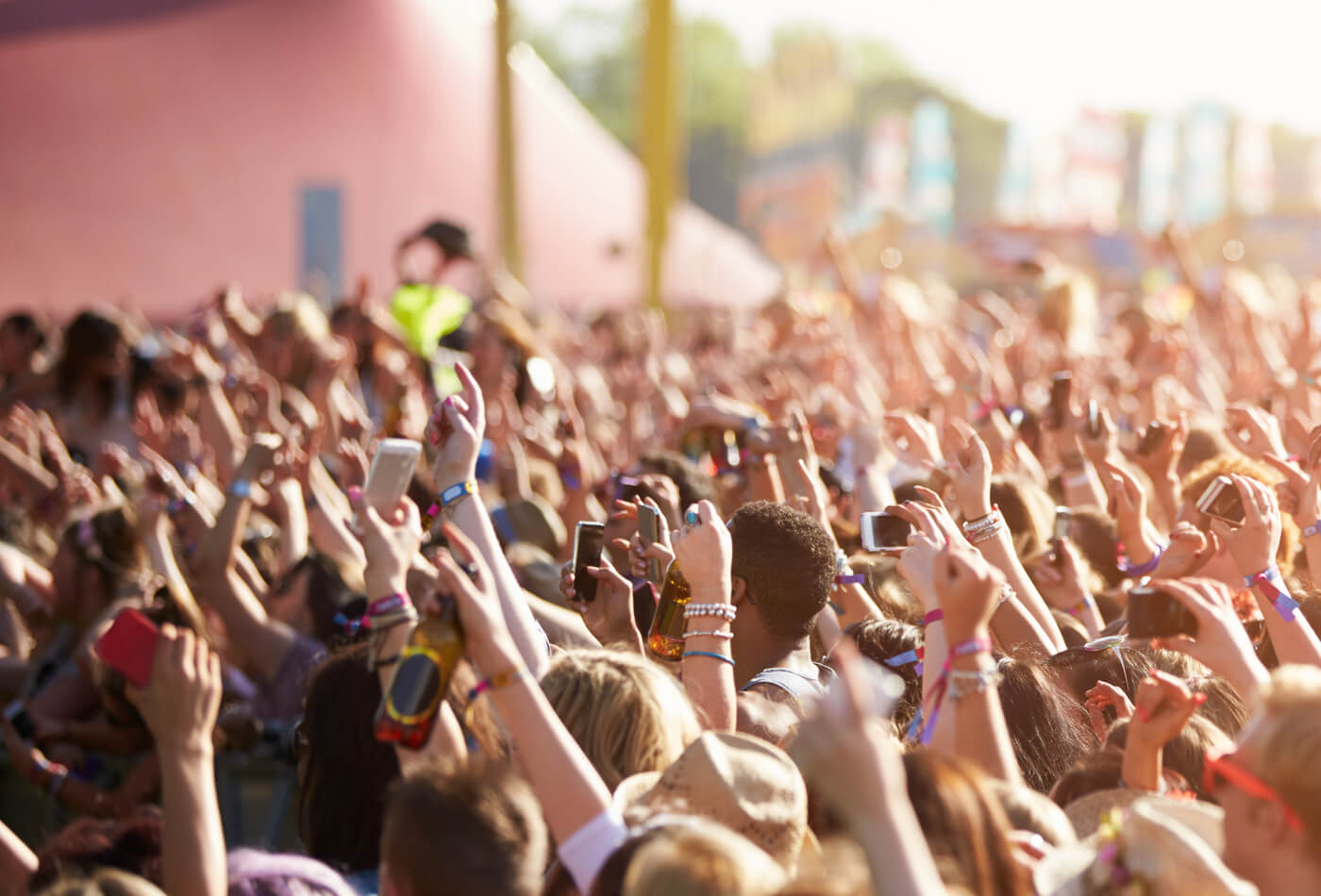 Audience with their hands in the air at an outdoor music festival