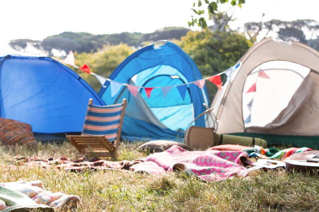 Three empty tents on a field at a festival