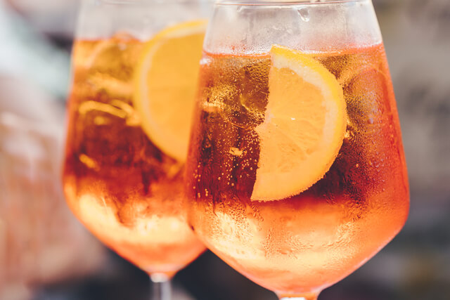 Two wine glasses filled with Aperol Spritz