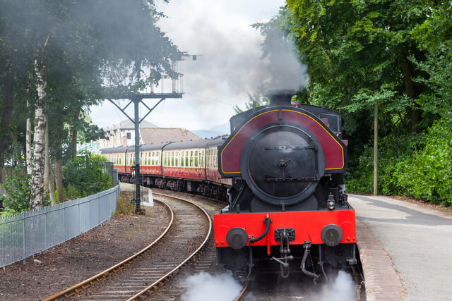 A heritage steam train leaving Lakeside Railway Station
