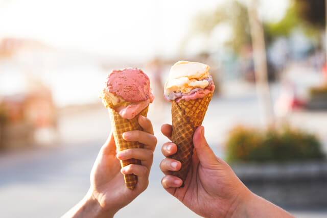 Two hands holding ice cream cones