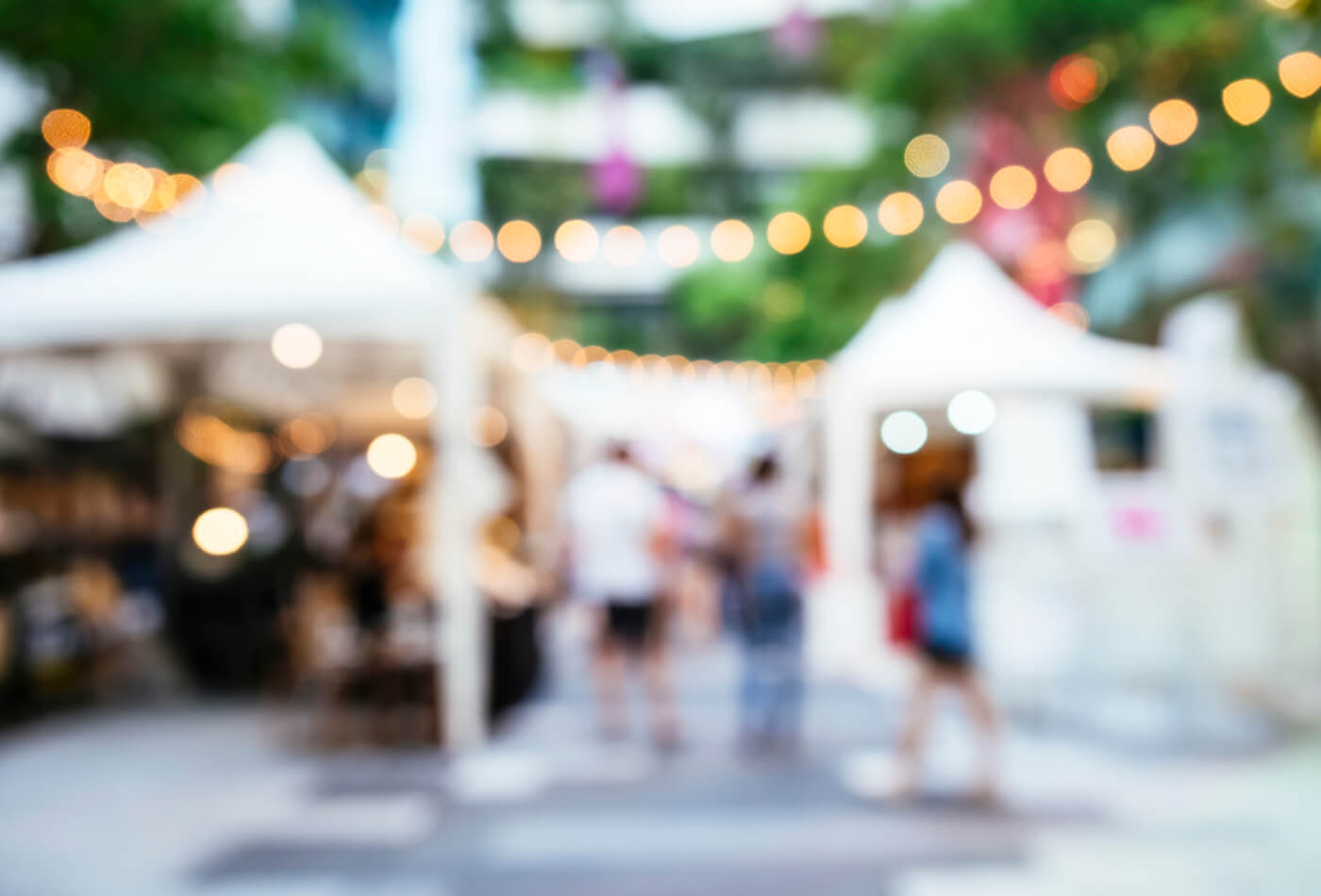 A blured image of an outdoor market stall with twinkly lights