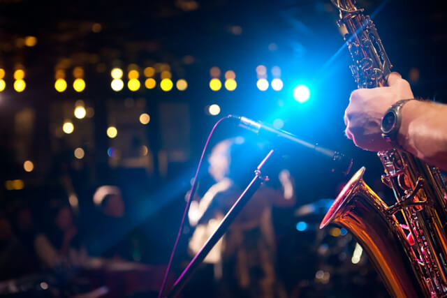 A saxaphone playing into a microphone on stage