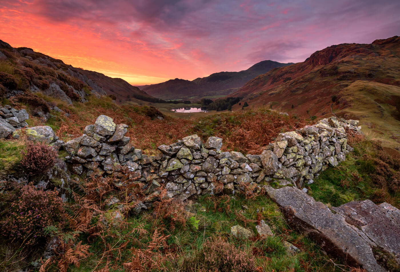 A shot of the Langdale Pikes and a stone wall at sunset