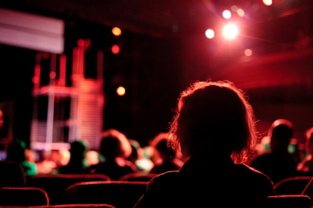 A woman watching a live performance at a theatre