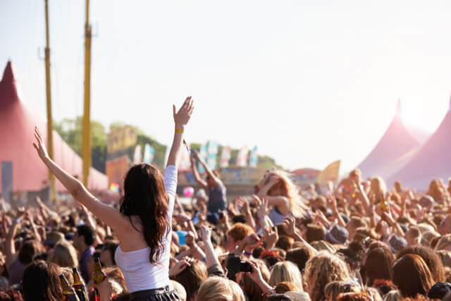Crowds with their hands in the air at a music festival