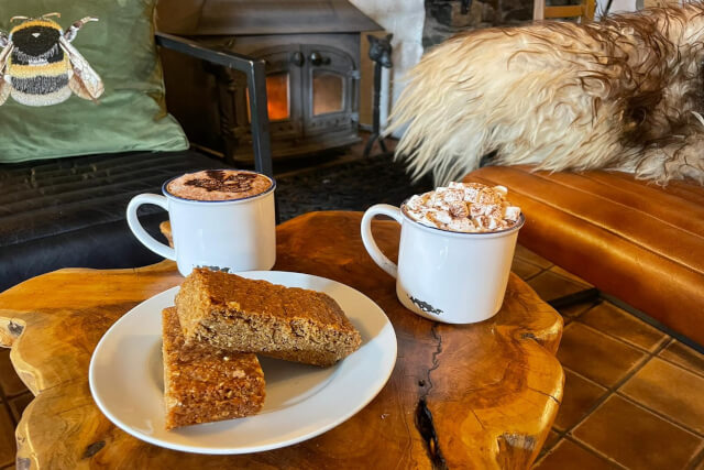 Two hot chocolates and flapjacks on a table at Sticklebarn in the Langdales