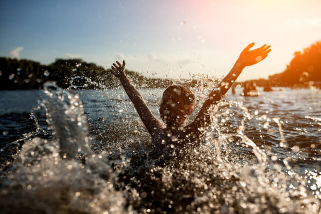 Young child splashing in open water 
