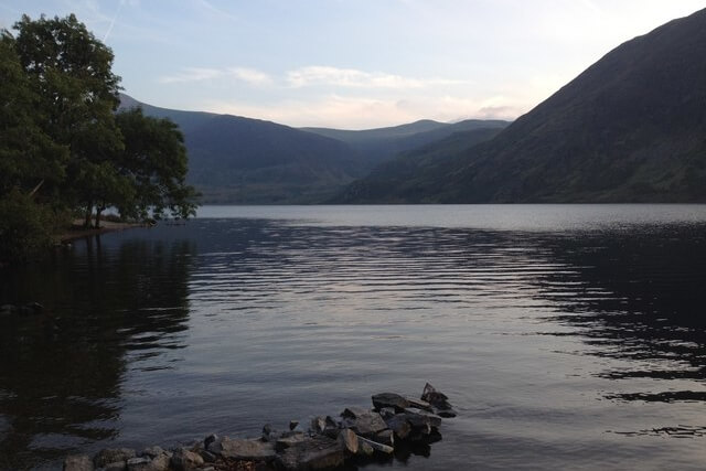 A view across the still water of Crummock Water to the mountains beyond 