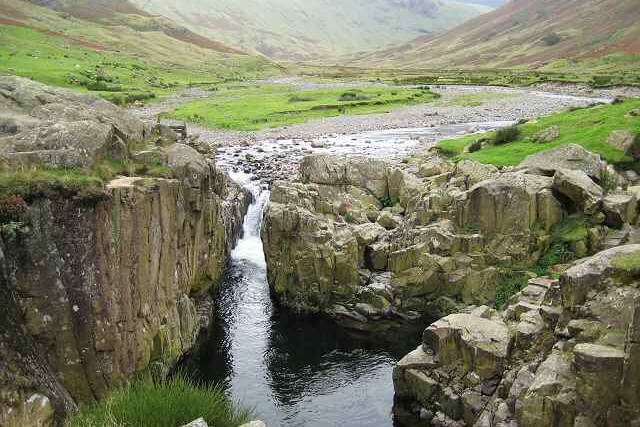 Black Moss Pot wild water swimming pool surrounded by rocky cliffs and green mountains 